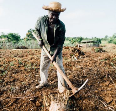 photo of man standing while holding pickaxe