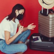young traveler sanitizing hand on red background