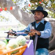 man in blue and white plaid long sleeve shirt and blue denim jeans wearing black hat