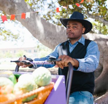 man in blue and white plaid long sleeve shirt and blue denim jeans wearing black hat