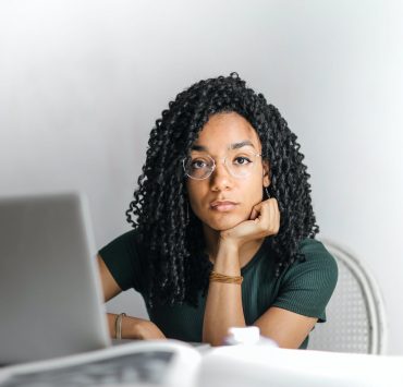 serious ethnic young woman using laptop at home