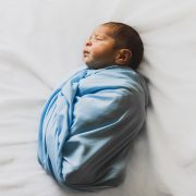 photo of new born baby covered with blue blanket