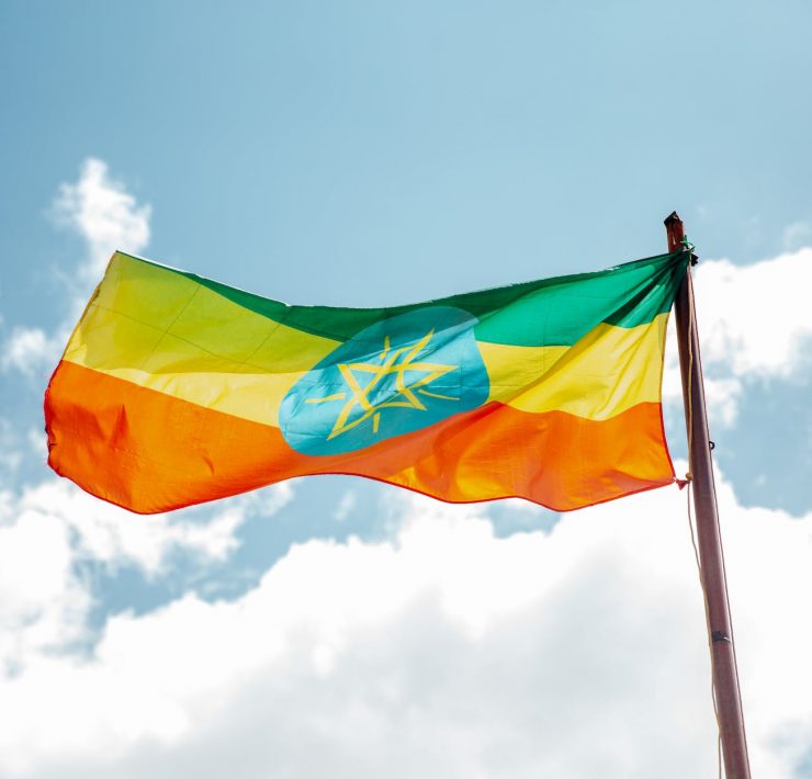 national colorful flag of ethiopia under cloudy sky