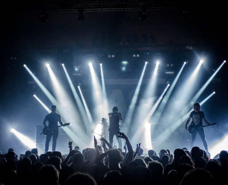 singer singing on stage beside guitar player and bass player