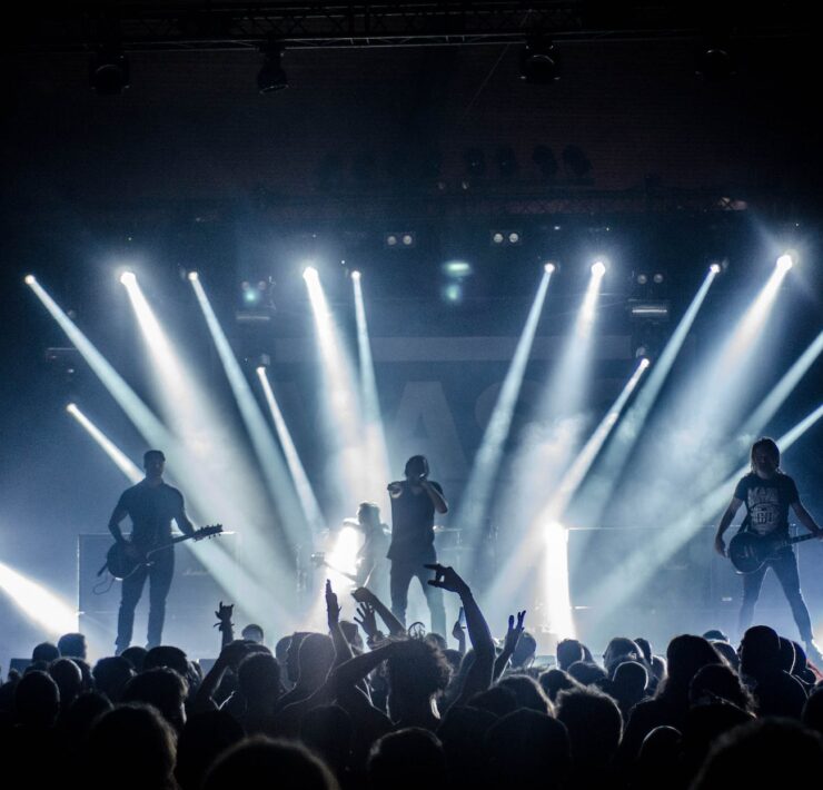 singer singing on stage beside guitar player and bass player