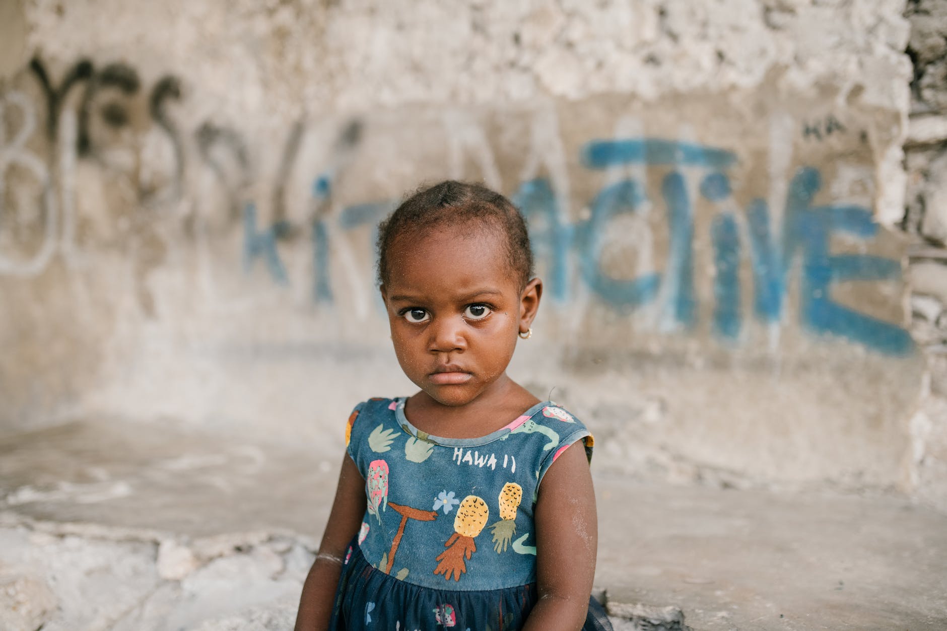 serious black girl against damaged concrete wall