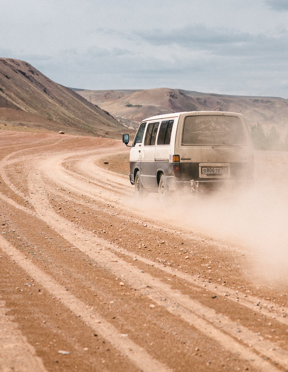 van on dusty road in mountainous valley
