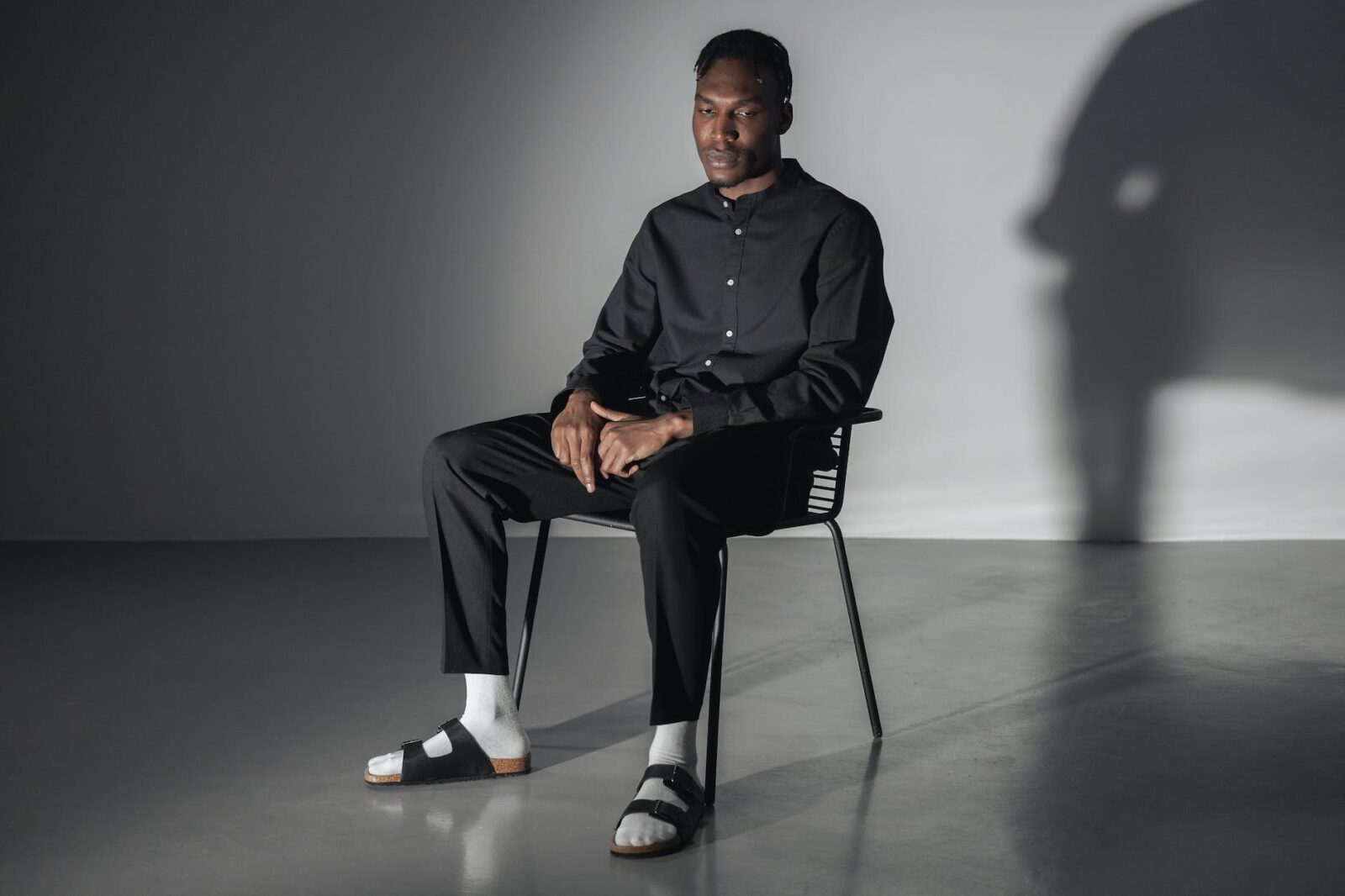man in black button up shirt sitting on black chair