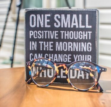 photo of a sign and eyeglasses on table