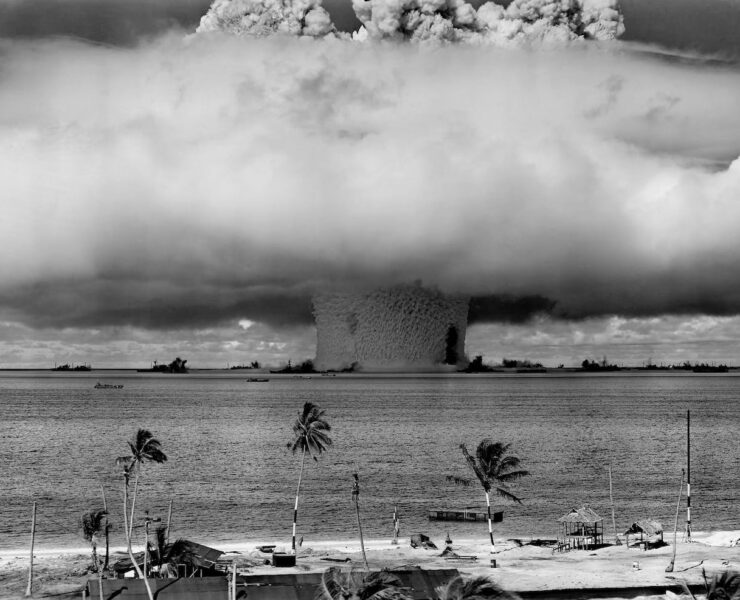 grayscale photo of explosion on the beach