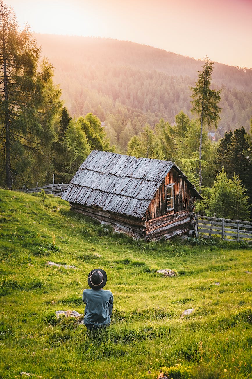 person sitting in front of brown and black house