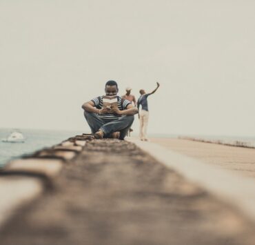 man sitting reading a book