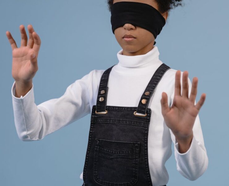a child with blindfold feeling the surroundings