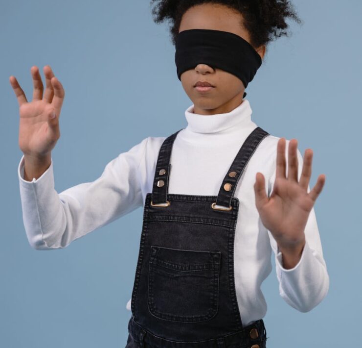 a child with blindfold feeling the surroundings