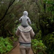 anonymous man with baby on shoulders walking away