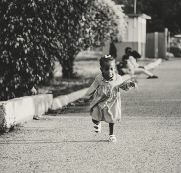 active ethnic kid running on street