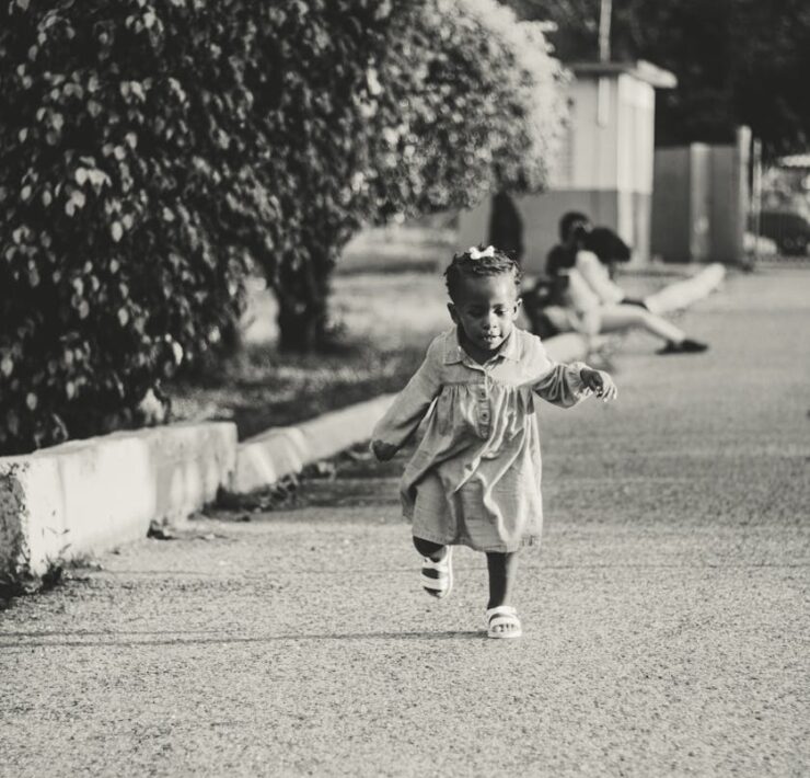 active ethnic kid running on street