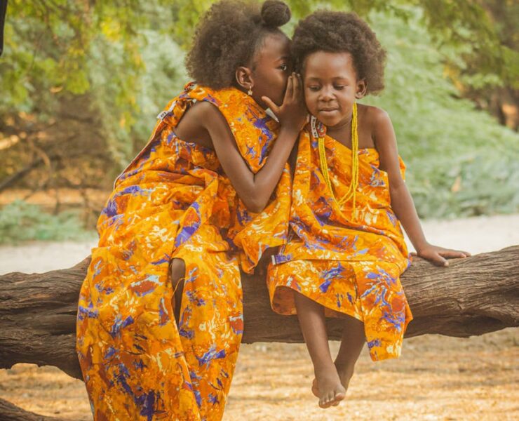 charming portrait of two girls in vibrant dresses outdoors