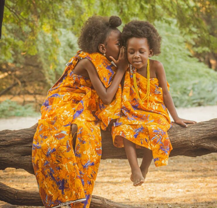 charming portrait of two girls in vibrant dresses outdoors