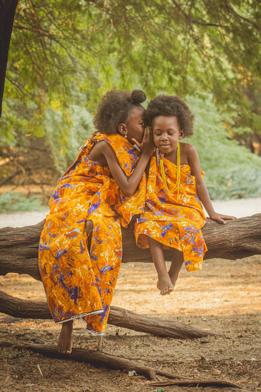 charming portrait of two girls in vibrant dresses outdoors